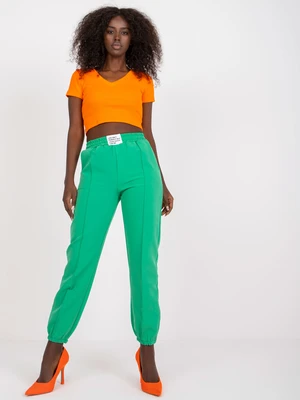 Dark green women's trousers made of fabric with wrinkled