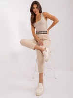Beige fabric trousers with decorative belt